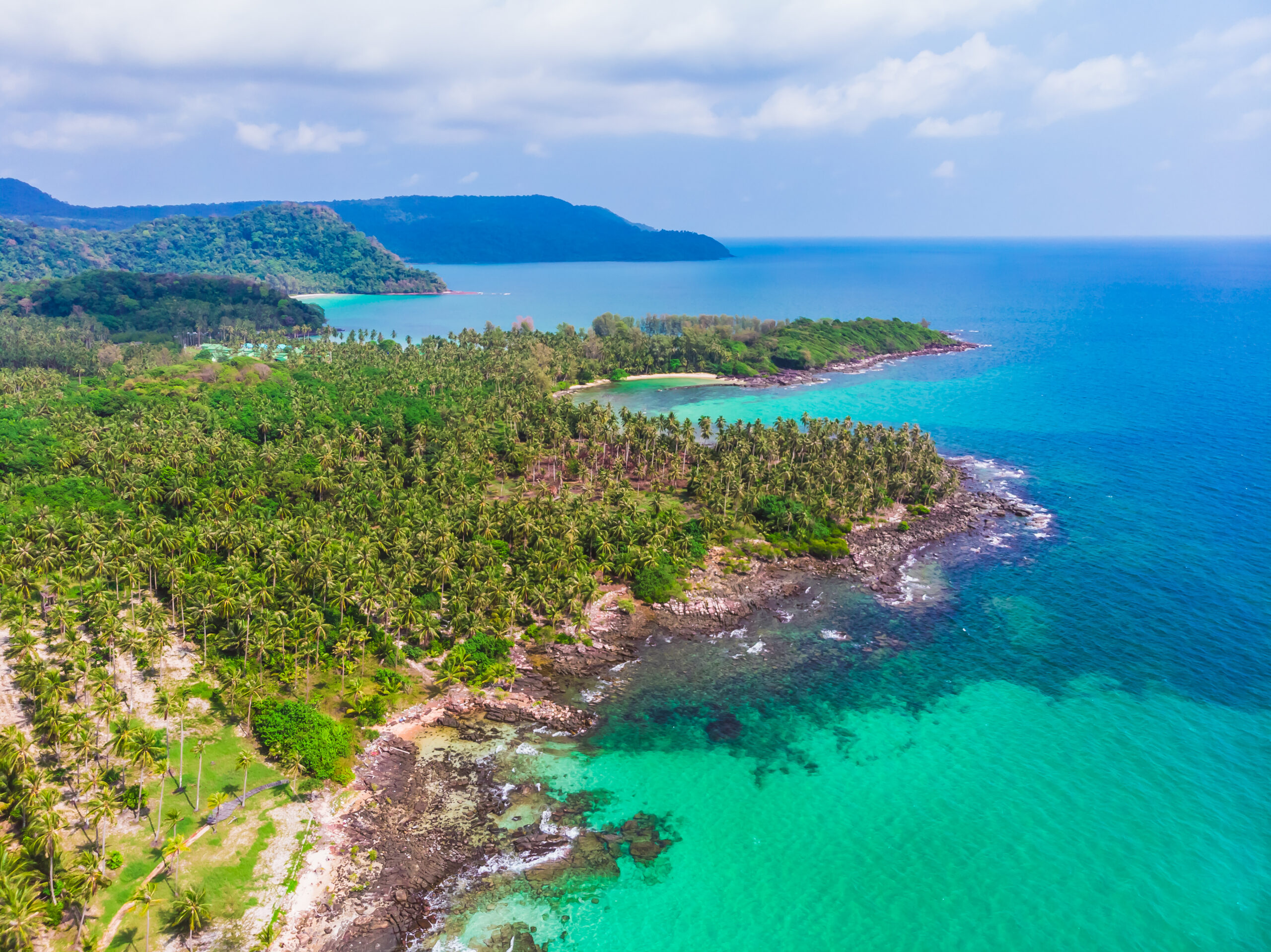 Aerial view of beautiful beach and sea with coconut palm tree on blue sky in the paradise island