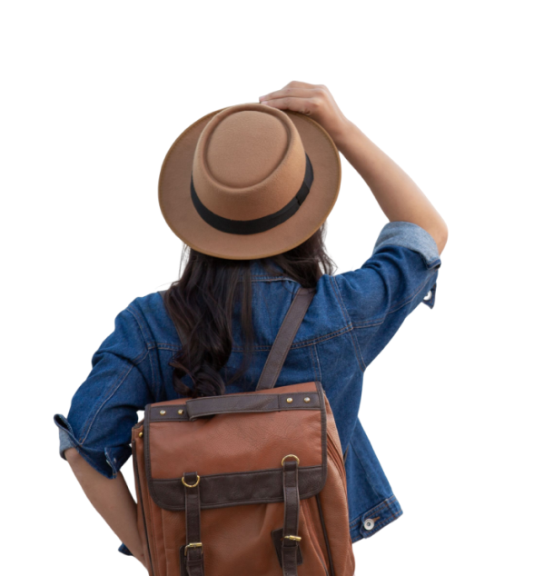 A female traveler with a brown leather backpack and fedora hat looks forward, ready for adventure in Indonesian tourist destinations like Rinjani or Mandalika.
